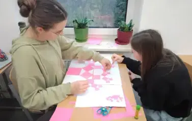 Uczennice siedzące przy stoliku i klejące Drzewo Pitagorejskie
