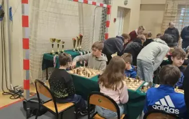 Rozpoczynamy turniej, uczniowie przygotowani na swoich miejscach, w tle puchary i medale