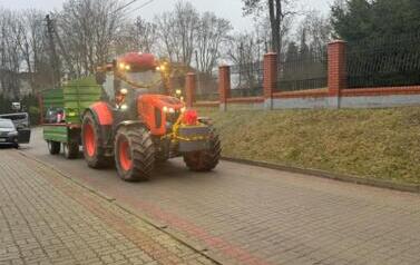 Czerwony traktor w świątecznych ozdobach