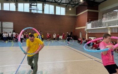 Uczestnicy turnieju biegają z hula-hop