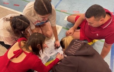 Grupa uczestnik&oacute;w Bitwy Mikołajkowej rozwiązuje kartę z zadaniami