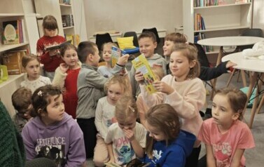 Grupa pierwszoklasist&oacute;w cieszy się z  wypożyczenia pierwszych książek