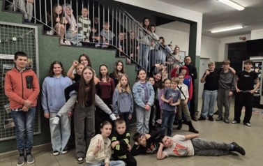 Grupa uczni&oacute;w na korytarzu szkolnym