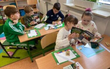 Uczniowie klasy drugiej przeglądają broszury związane z biezpieczeństwwem w gospodarstwie rolnym