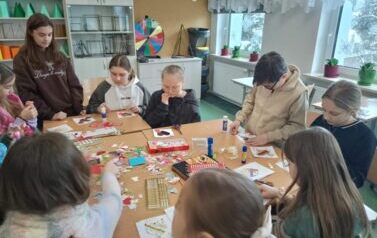 Uczniowie przy stole wykonują kartki walentynkowe