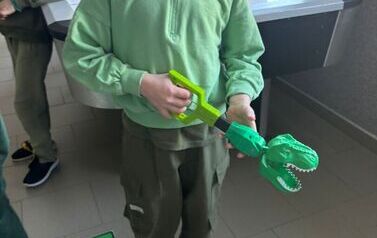 Chłopcie z zabawką w kształcie dinozaura