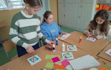 Uczenice przy stole wykonują kartki wielkanocne