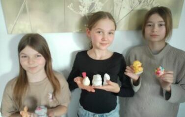 Uczennice trzymają wielkanocne figurki gipsowe