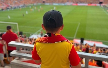 Uczeń naszej szkoły ogląda mecz na stojąco