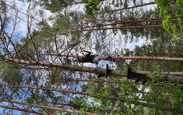 Chłopiec idzie po linie zawieszonej wysoko nad ziemią