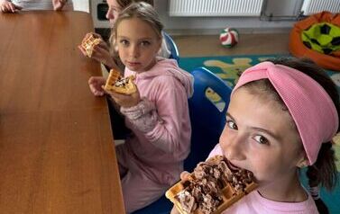 Dziewczynki jedzą gofry w świetlicy szkolne