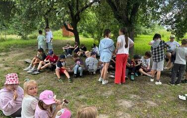 Dzieci jedzą kiełbaski z ogniska