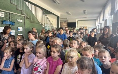 Uczniowie z uwagą ogldają występ ch&oacute;ru podczas występu.jpeg