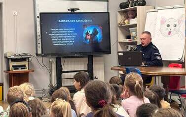 Dzieci biorą udział w spotkaniu z funkcjonariuszem policji