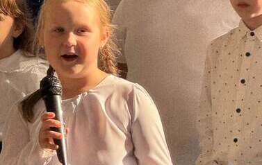 uuczennica trzyma mikrofon i śpiewa