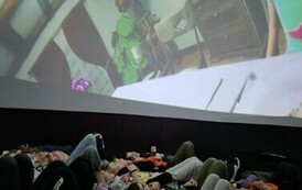 Grupa dzieci uczestniczy w projekcji filmy w formacie 360 stopni