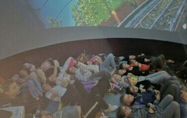 Grupa dzieci uczestniczy w projekcji filmy w formacie 360 stopni.