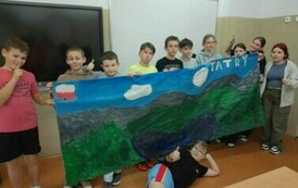 Grupa uczni&oacute;w trzyma plakat przedstawiający Tatry