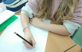 Dziewczynka zapisuje na białej kartce cyfry