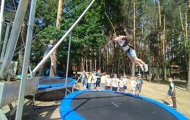 Chłopcy skaczą na trampolinach.