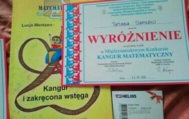 Na zdjęciu widnieje dyplom, książka oraz bilet do kina przyznane uczennicy za wynik w konkursie Kangur Matematyczny.