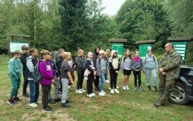Grupa uczni&oacute;w słuchająca wykładu Leśniczego.