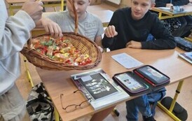 Przewodnicząca Samorządu Uczniowskiego częstuje cukierkami z okazji Dnia Chłopaka.