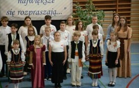 Uczniowie klas IV-VIII w strojach galowych i ludowych.