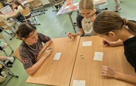 Trzy dziewczynki z klasy piątek grają w bingo z tabliczką mnożenia.
