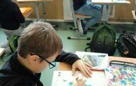 Uczniowie piszący na kartce.
