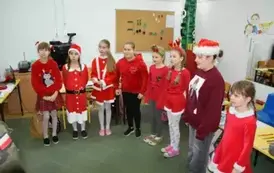 Uczennice klasy trzeciej w czerwonych strojach mikołajkowych.