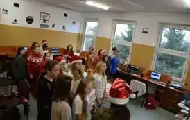 Uczniowie klasy piątej śpiewają piosenkę Mikołajowi.