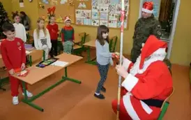 Mikołaj wręcza prezent uczennicy z klasy drugiej.