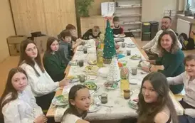 Uczniowie klasy si&oacute;dmej z wychowawcą przy wigilijnym stole