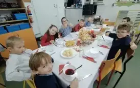 Uczniowie klasy pierwszej pozują do zdjęcia przy świątecznym stole