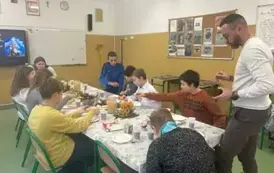 Uczniowie klasy sz&oacute;stej z nauczycielem przy wigilijnym stole