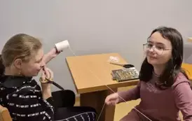 Dwie dziewczynki przygotowują sznurek do dekoracji zimowej