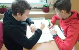 Chłopcy rozwiązują zadania walentynkowe.