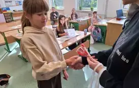 Uczennica klasy trzeciej otrzymuje nagrodę za udział w konkursie walentynkowym