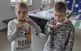 Dw&oacute;ch chłopc&oacute;w z klasy pierwszej z pączkami