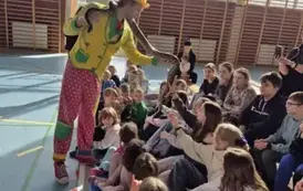 Treser pokazuje węża boa dzieciom