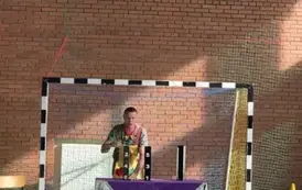Mężczyzna stoi za stołem i prezentuje sztuczkę cyrkową
