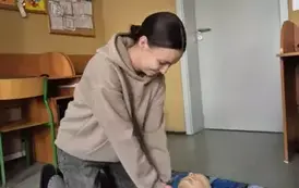 Uczennica klasy &oacute;smej wykonuje ćwiczenia na fantomie