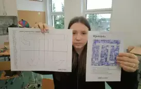 Uczennica trzymająca w rękach prace swojej grupy