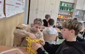 Dw&oacute;ch chłopc&oacute;w buduję bryłę liczby Pi z klock&oacute;w reko