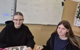 Dwie uczennice w sali matematycznej wykonują mandalę z okazji Dnia Liczby Pi