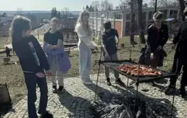 Uczniowie pieką kiełbaski na ognisku