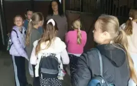 Uczennice stoją tyłem z plecakami
