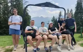 Uczniowie z dyrektorem na ławeczce widokowej przed zjazdem kolejką na Butorowym Wierchu