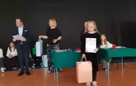 Uczennica pozuje z nagrodą i dyplomem
